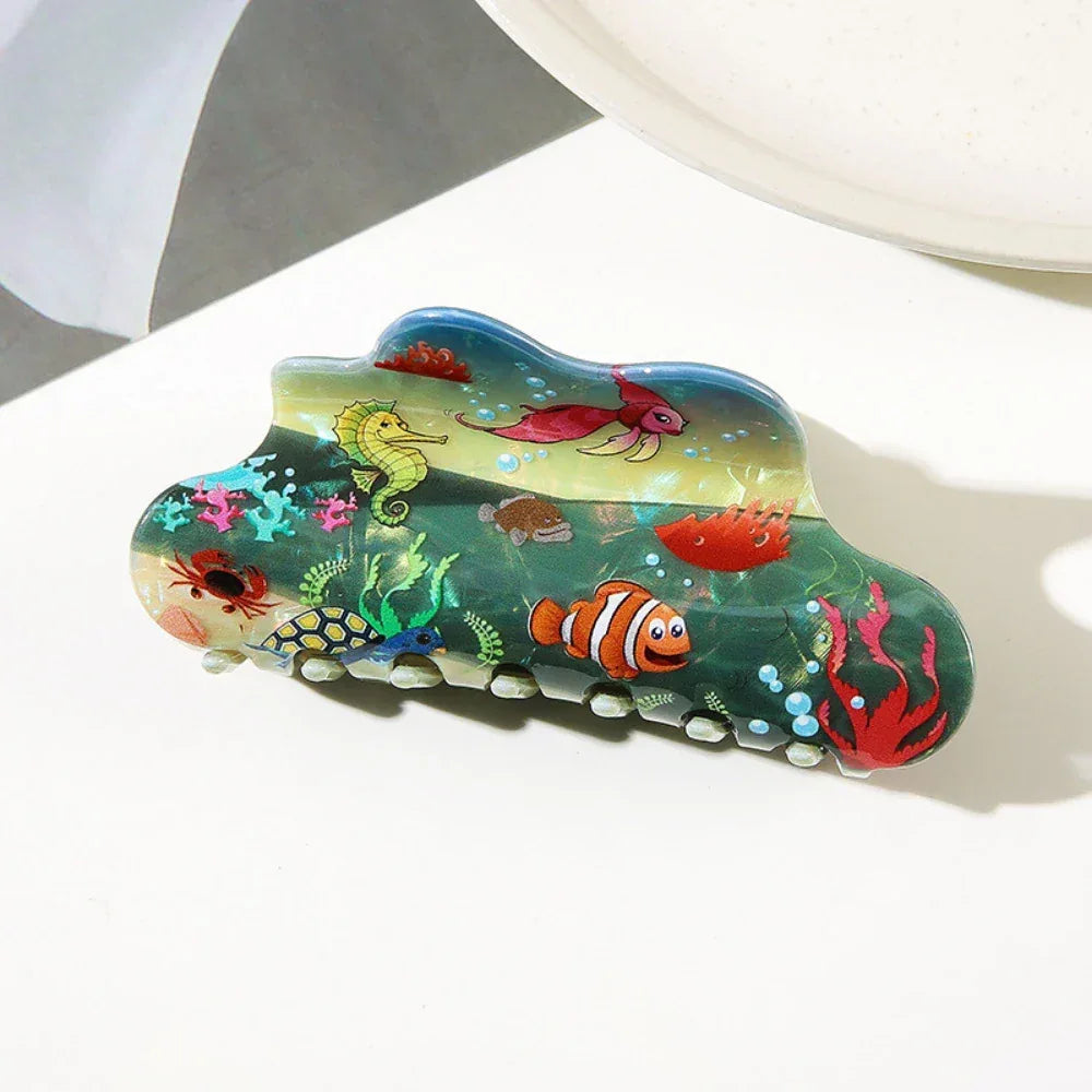 Close-up of a cloud-shaped hair claw with an underwater scene featuring a seahorse, clownfish, and coral
