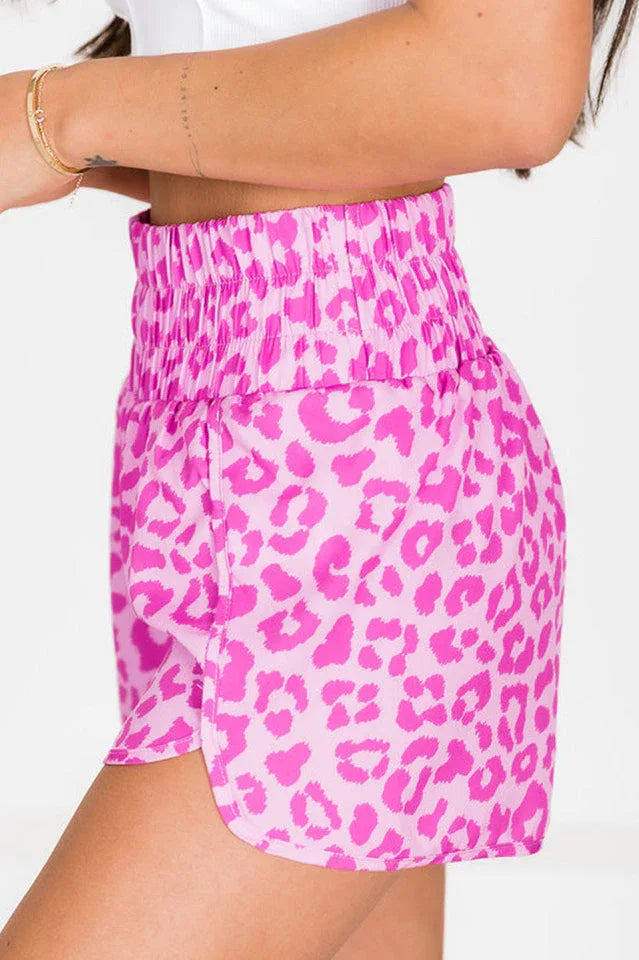 Side view of pink leopard print athletic shorts with a high-waisted elastic band