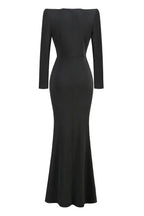 Back view of a long black formal dress with a fitted silhouette and a mermaid hem.