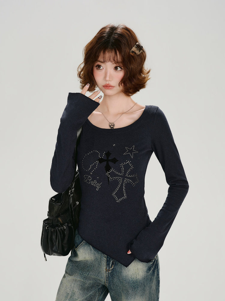 Woman wearing a dark blue long-sleeve top with a graphic print and asymmetrical hem, paired with distressed jeans.
