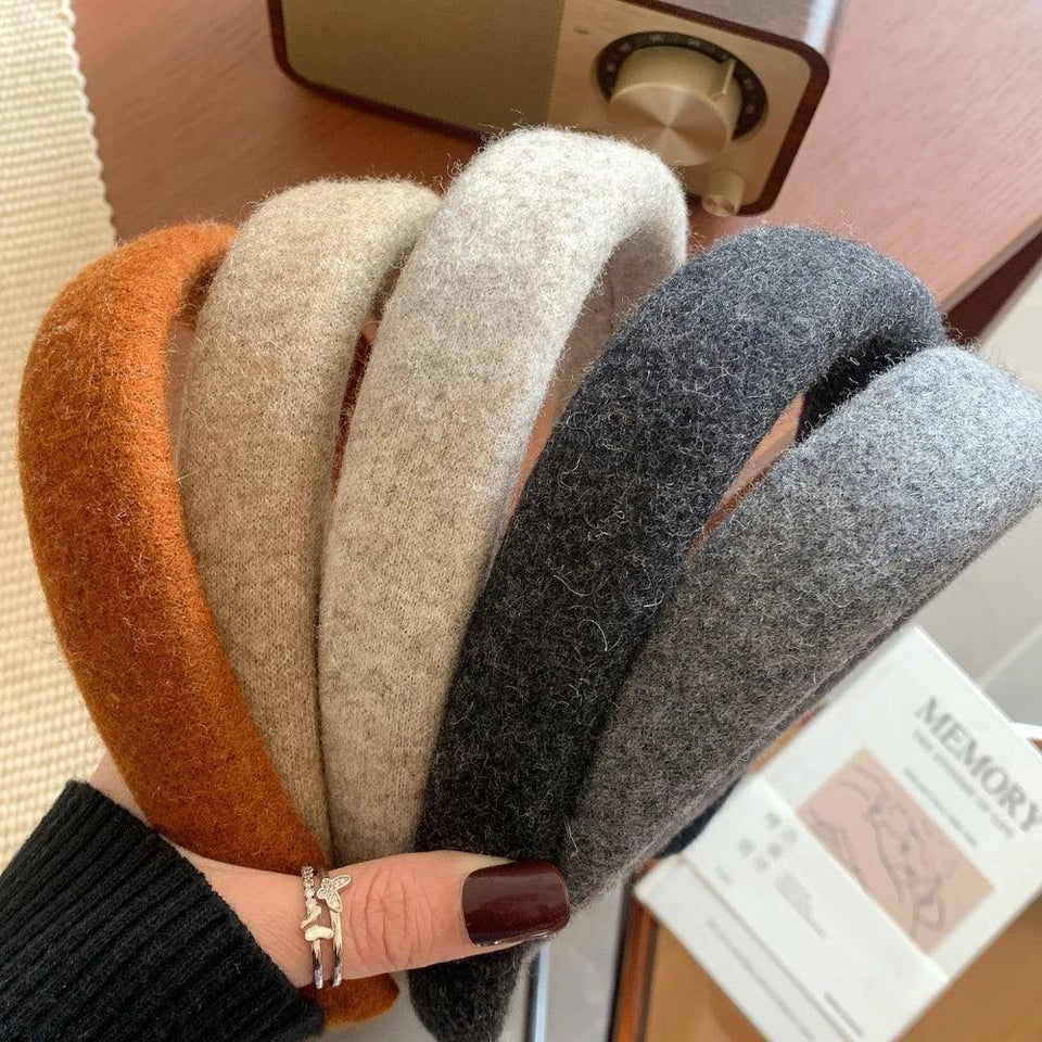 A hand holding a collection of padded headbands in various earth tones: brown, beige, light gray, and dark gray. Secondary image