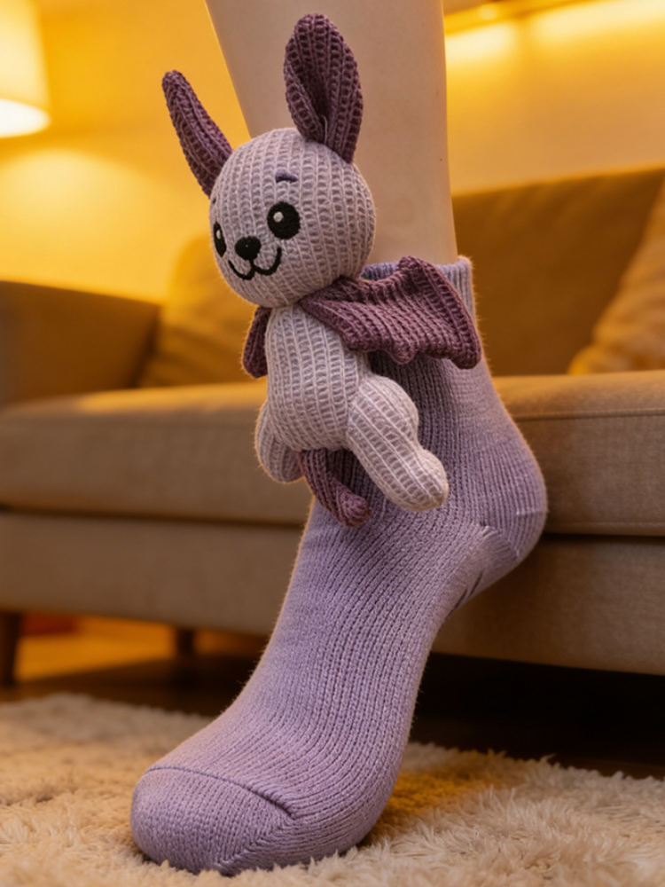 Close-up of a light purple ankle sock with a plush bat character attached to the cuff, worn on a person's foot.