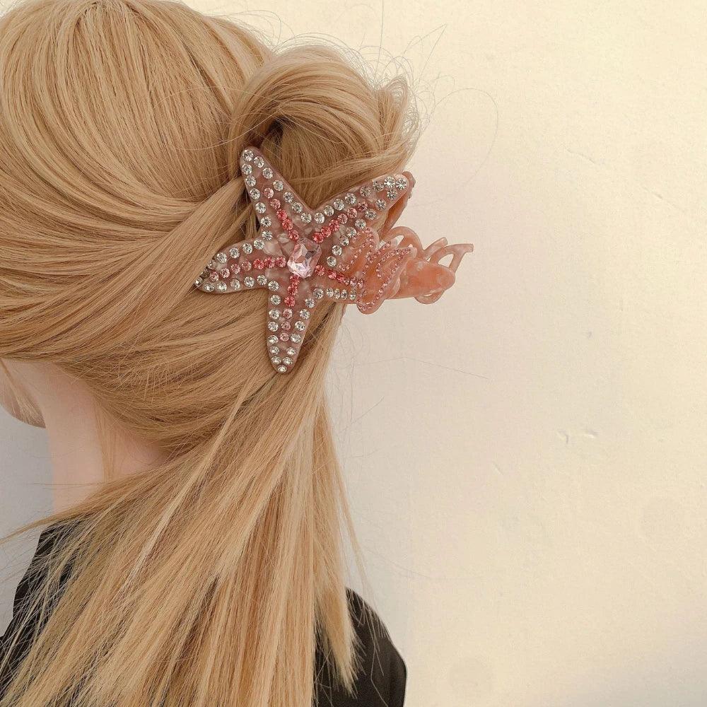 A blonde woman wearing a pink rhinestone-embellished starfish hair claw clip in her updo