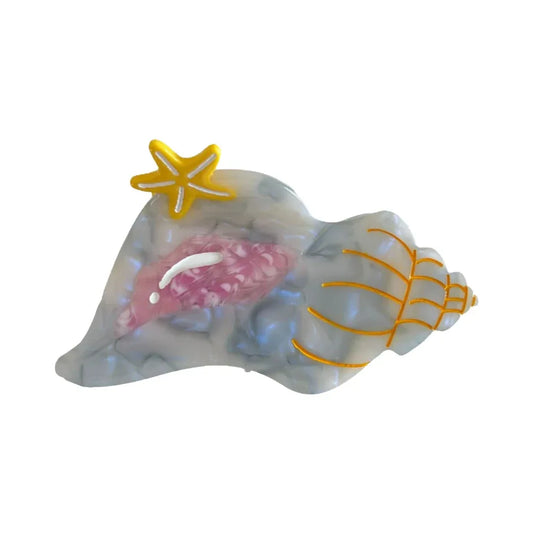 A translucent seashell-shaped hair clip with a yellow starfish accent and pink interior detailing, against a white background.