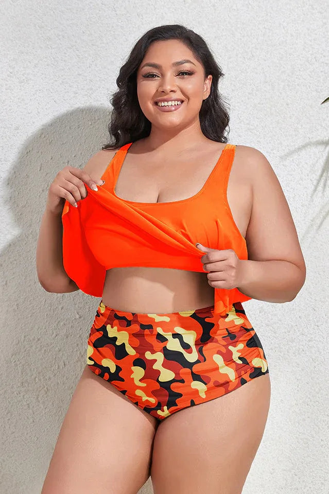 Plus-size woman adjusting the ruffle on an orange tankini top with camouflage bottoms