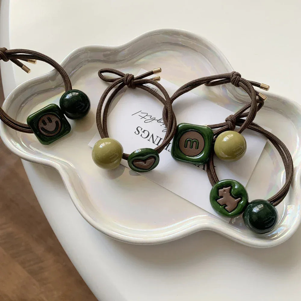 Hair ties arranged on a white, wavy-edged tray.