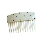 A white hair comb with colorful rhinestones scattered across the top.