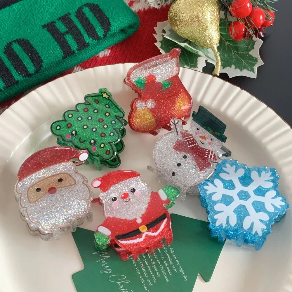 Set of glittery Christmas hair claw clips featuring Santa, snowman, Christmas tree, and stocking on a plate