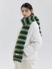 Model wearing a white puffer jacket and a green and blue striped scarf.