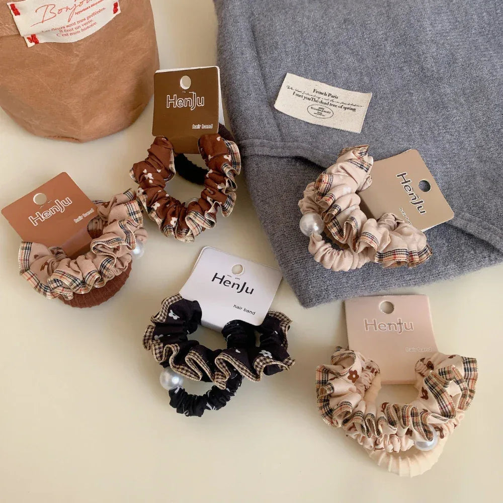 Group of scrunchies presented on a grey knit fabric, alongside other accessories