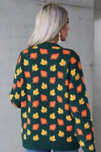 Back view of a woman wearing a dark green sweater adorned with an all-over maple leaf print in orange and yellow.