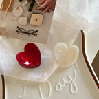 White and red heart-shaped hair clips on a tray