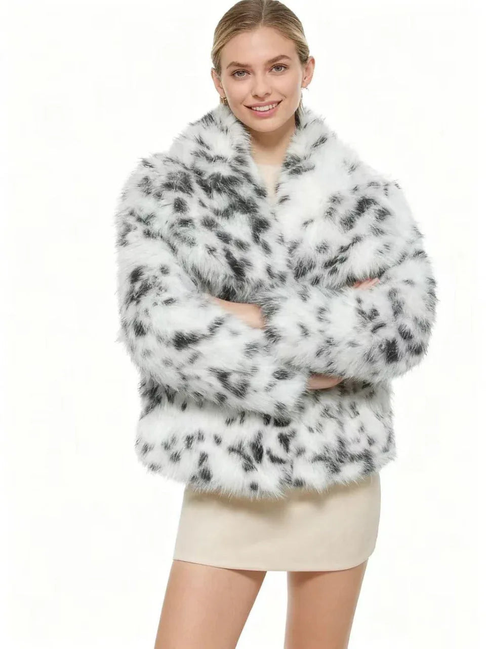 smiling woman wearing a dalmatian print faux fur cropped jacket