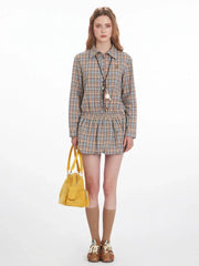 Model wearing a plaid shirt dress with a yellow handbag, front view