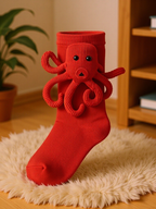 Red sock with an embroidered red octopus applique on a fluffy rug