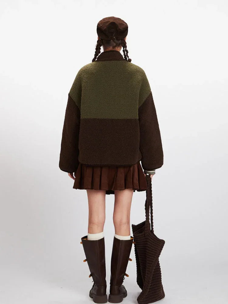 Back view of a woman wearing a colorblock fleece jacket with a brown corduroy skirt and boots