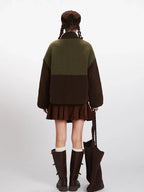 Back view of a woman wearing a colorblock fleece jacket with a brown corduroy skirt and boots