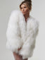 Woman wearing a white fluffy faux fur oversized jacket and white lace stockings