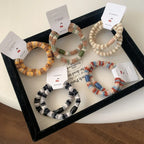 A selection of fuzzy hair ties in a tray, showcasing diverse color combinations and bead details.