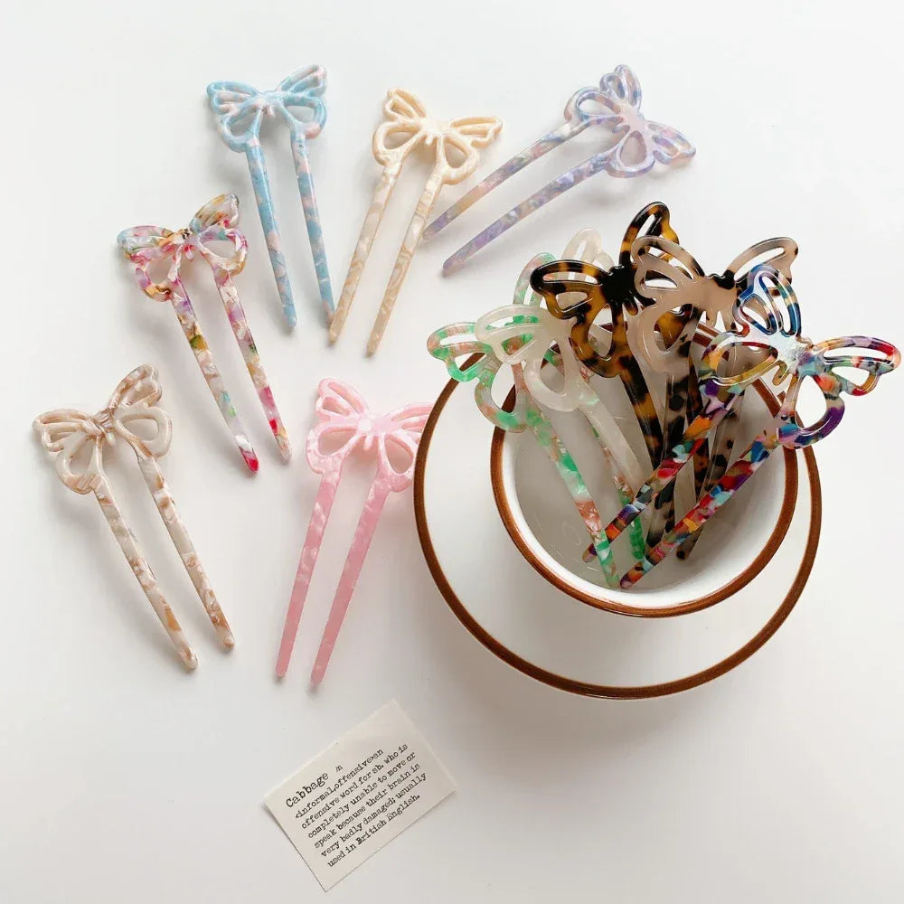 various butterfly hair sticks arranged around a bowl and a teacup