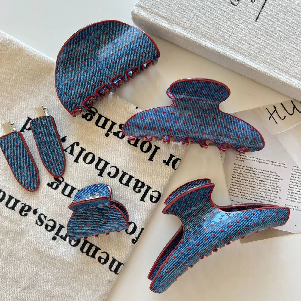 Selection of blue polka dot hair accessories with red trim laid out with text