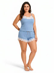 Side view of a woman in a blue camisole and shorts pajama set, showcasing the lace trim and ribbed texture.