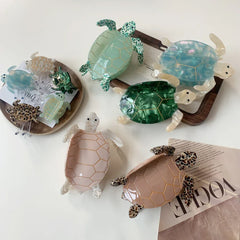 Various turtle hair clips, including large and small sizes, in pastel and jewel tones