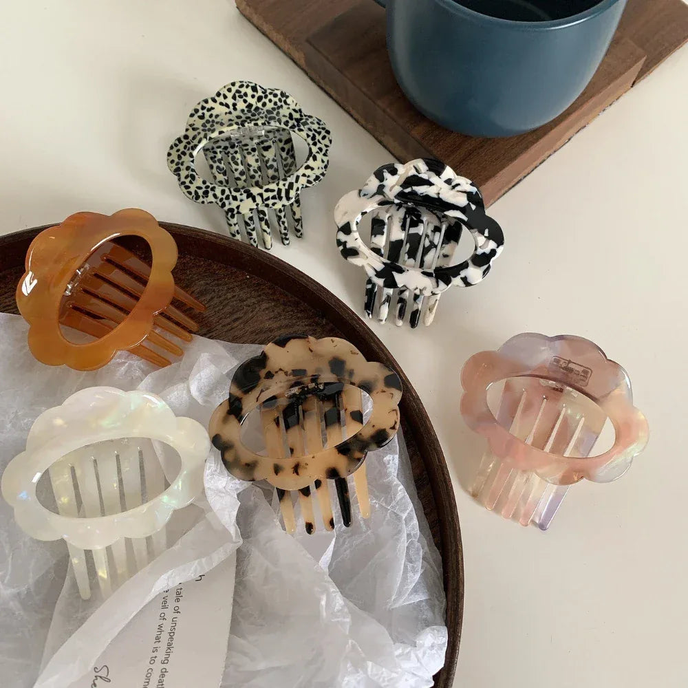 A close-up of a collection of cloud-shaped hair clips in various patterns and colors