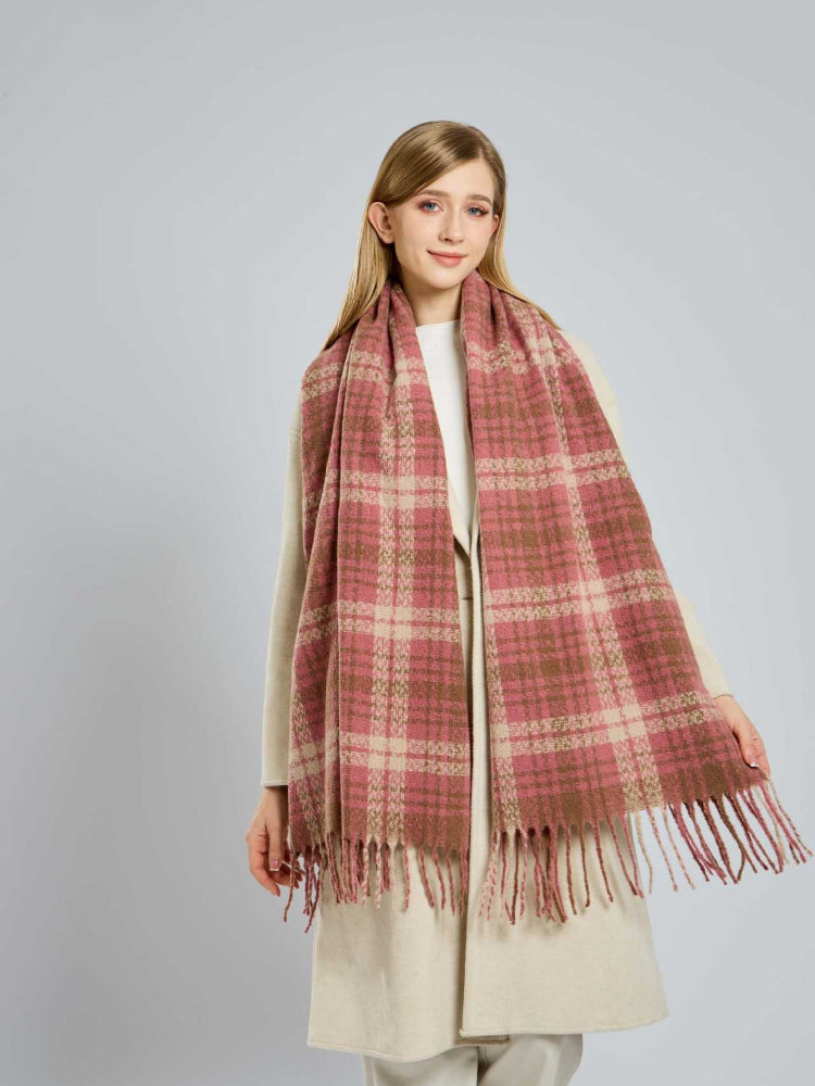 Front view of a woman modeling a large, fringed plaid scarf.