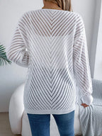 Back view of a woman wearing a white open-knit chevron pattern cardigan.