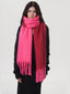 Woman wearing a black sweater and a two-toned pink and red scarf, wrapped around her neck.