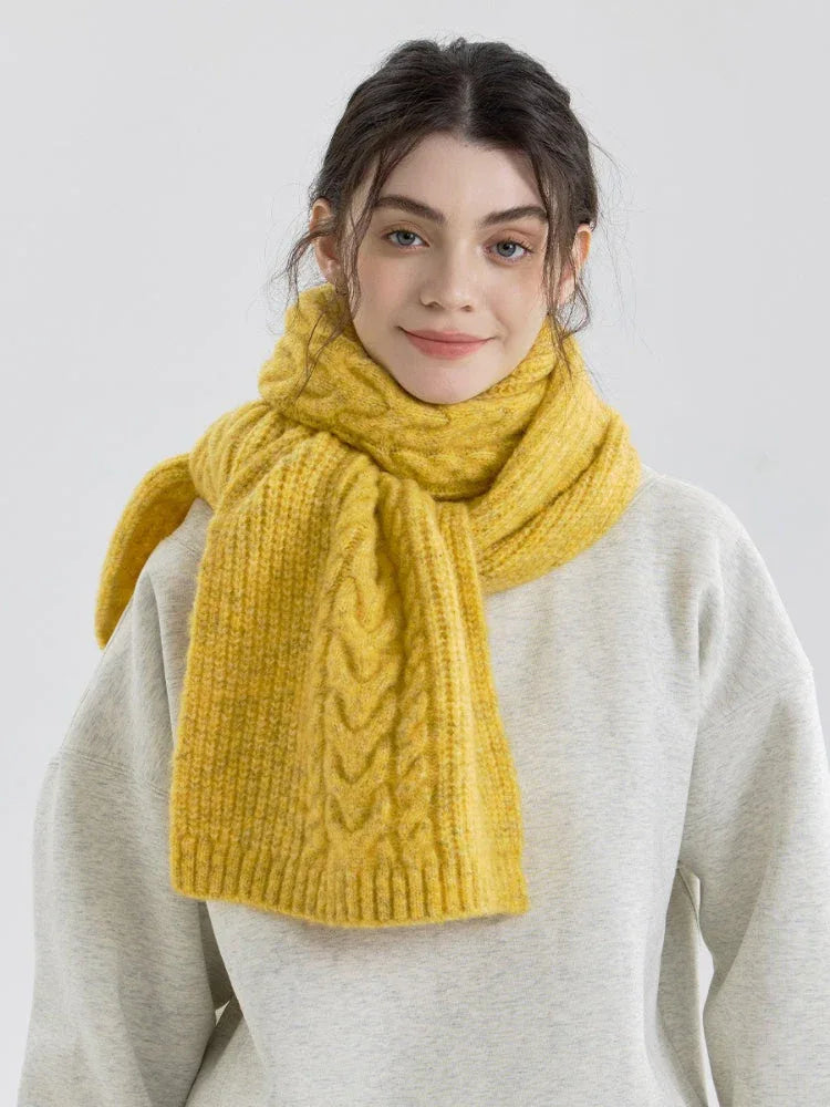 Woman wearing a yellow cable knit scarf with a gray sweatshirt