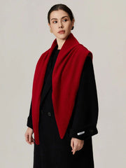 Woman wearing a red scarf draped over a black coat, front view