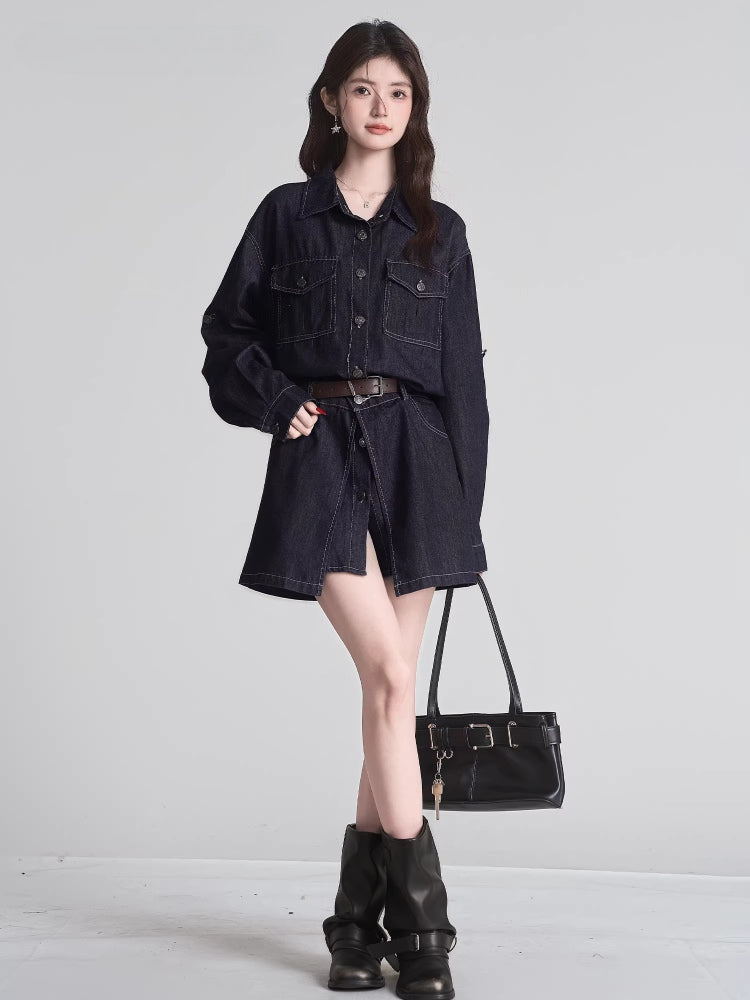 Full body shot of a woman in a dark wash denim shirt dress with a brown belt, holding a black handbag and wearing black boots.