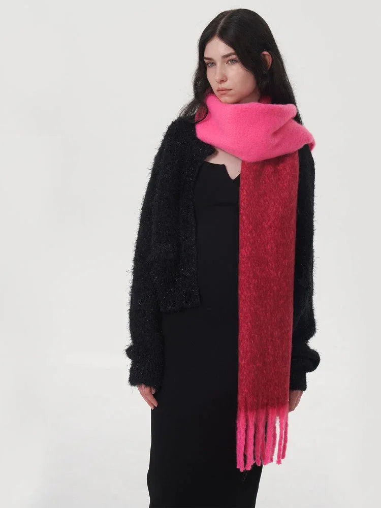 Close-up of a woman wearing a black sweater and a two-toned pink and red scarf.