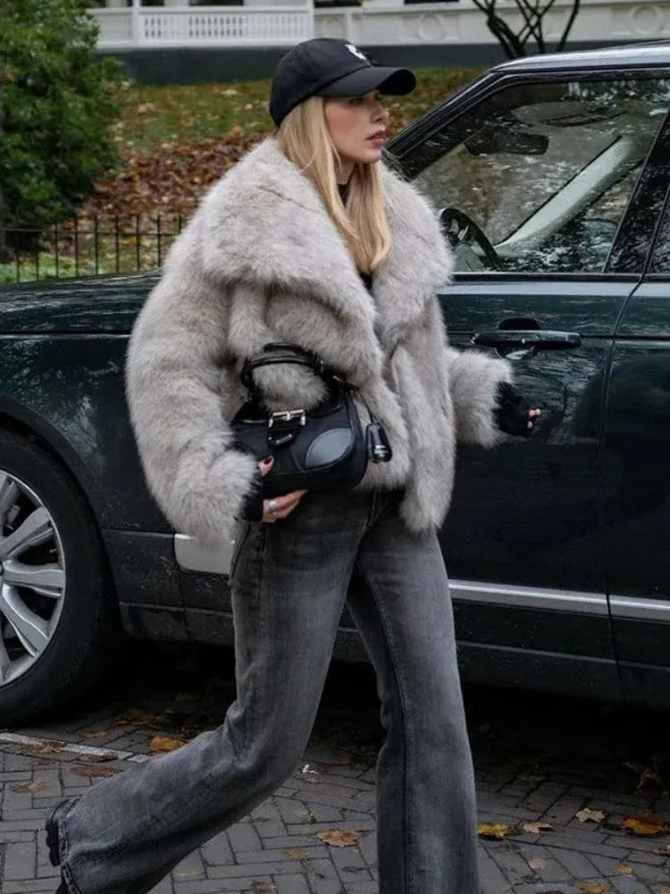 Woman wearing a light grey oversized faux fur jacket with black jeans