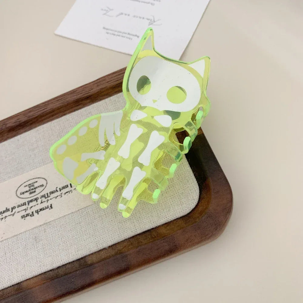 Neon green skeleton cat claw hair clip on a wooden tray