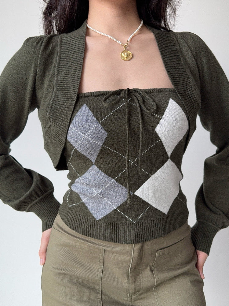 Woman wearing a green argyle knit tube top with a matching cropped bolero cardigan and khaki skirt.