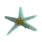 A light blue translucent acrylic starfish hair clip with a gold central star and gold dots.