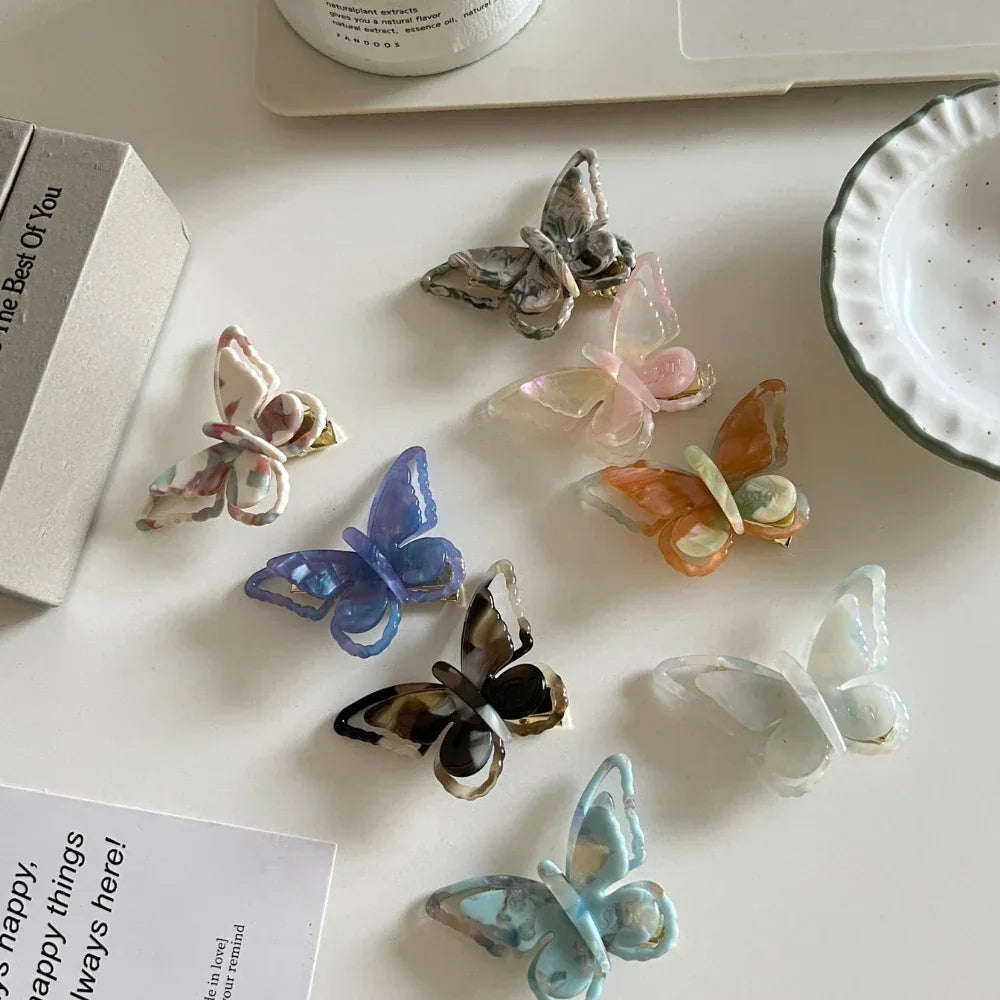 assortment of translucent butterfly hair clips on a white surface
