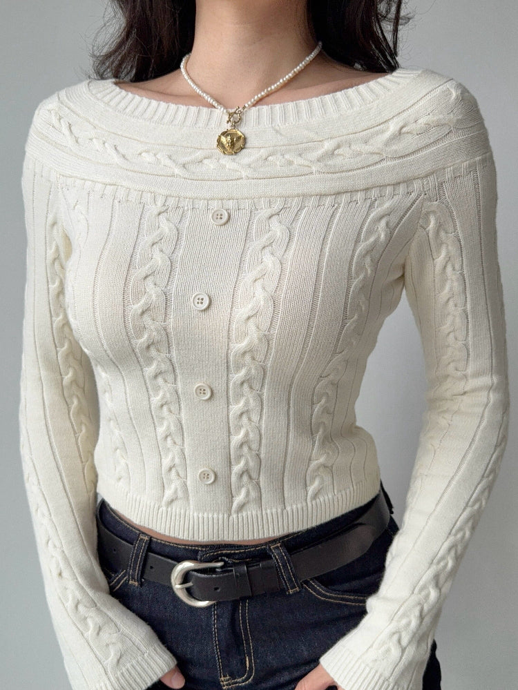 Close-up of a cream cable knit cropped sweater with an off-the-shoulder neckline and button details. Main image