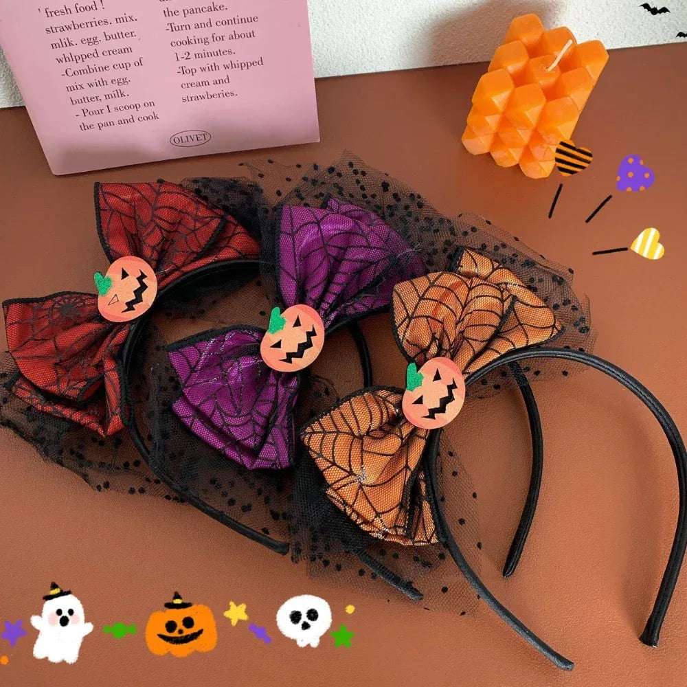 Three Halloween themed headbands with spiderweb bows and pumpkin accents, layered over black tulle.