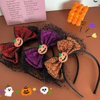 Three Halloween themed headbands with spiderweb bows and pumpkin accents, layered over black tulle.