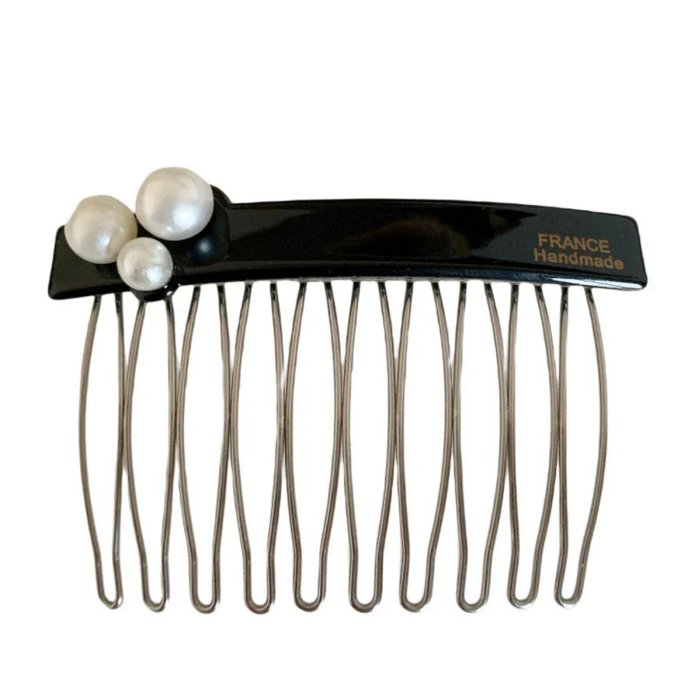 Close-up of a black hair comb with three white pearls on the top left and the inscription "FRANCE Handmade" on the top right, against a white background. Main image