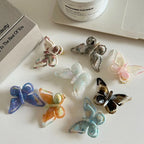 various translucent butterfly hair clips arranged on a white surface