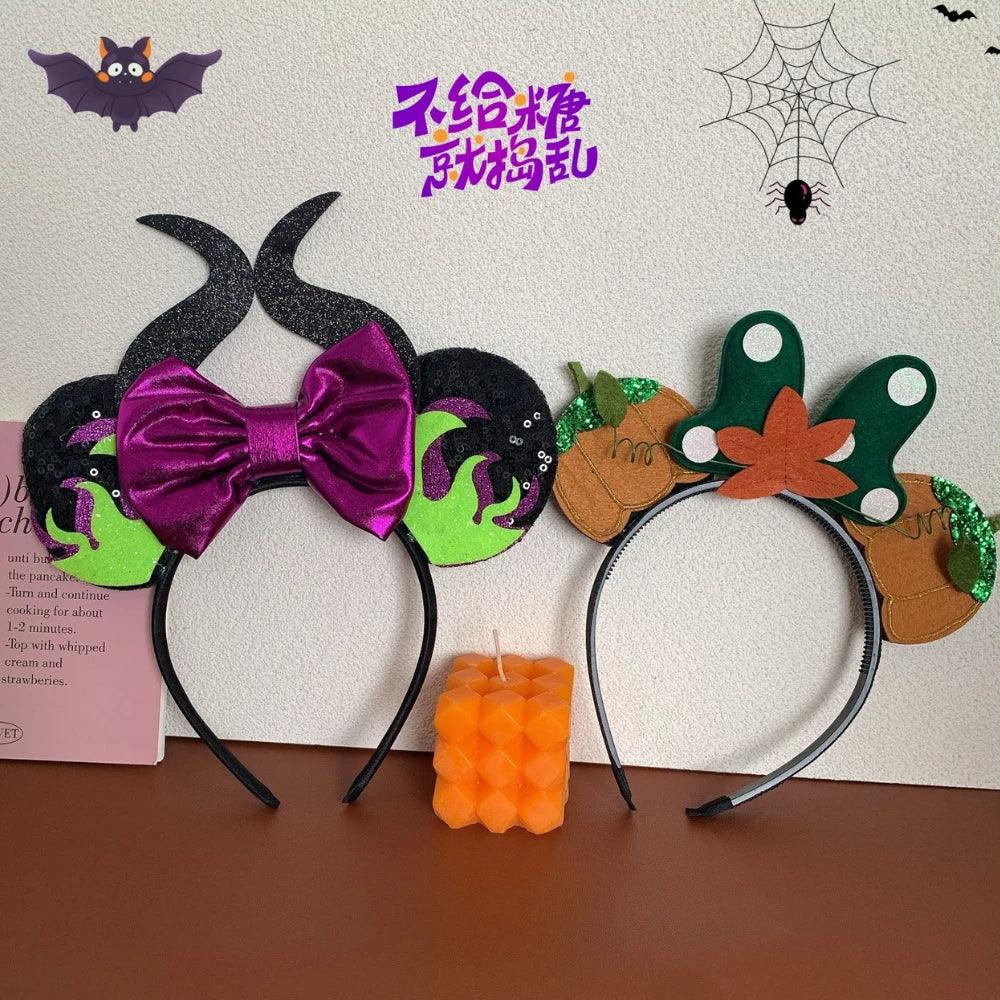 Two Halloween themed headbands, one with devil horns and a purple bow, the other with pumpkin and leaf accents.