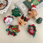 Arrangement of plush Christmas-themed hair accessories and ornaments on a light-colored surface