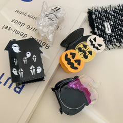 Collection of Halloween themed hair clips including pumpkins, ghosts, a haunted house, and a cauldron