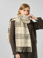 Woman adjusting her cream, brown, and grey plaid scarf