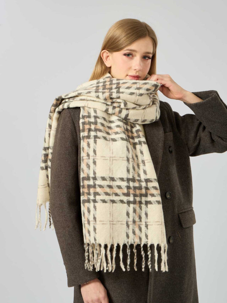 Woman adjusting her cream, brown, and grey plaid scarf